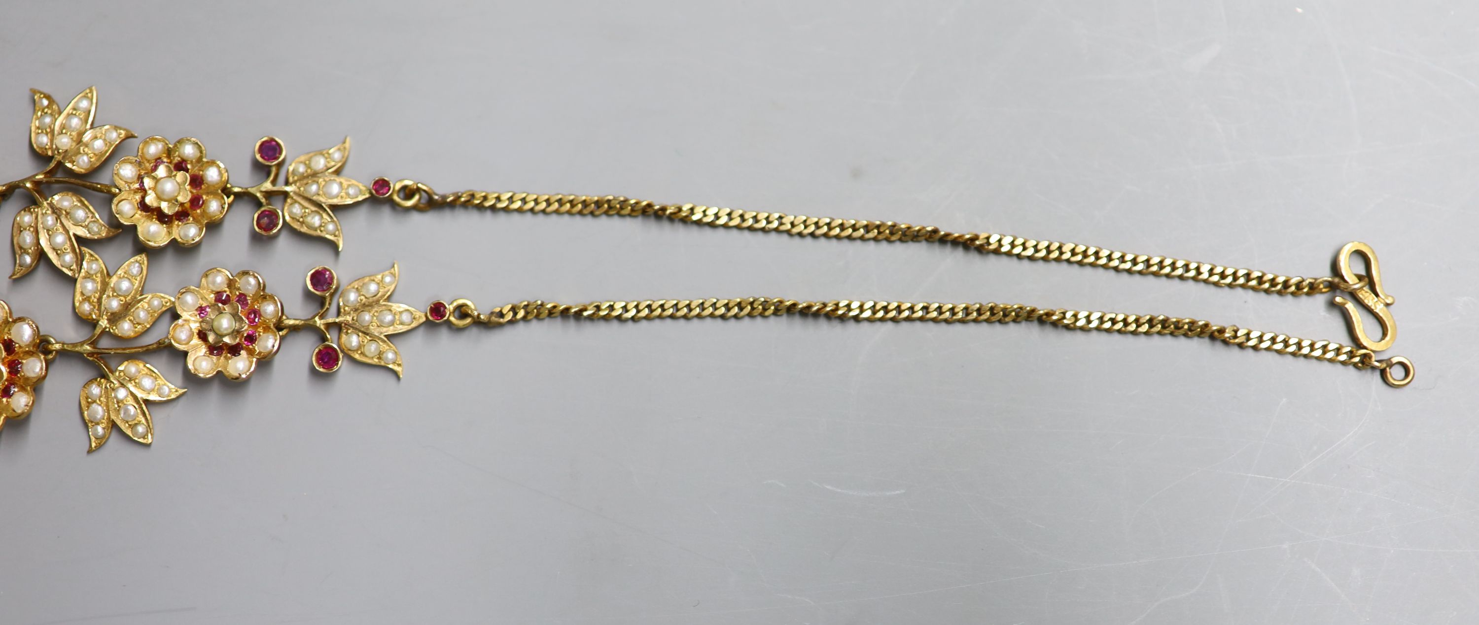 An early to mid 20th century Indian gilt metal, ruby and split pearl floral cluster drop necklace, approx. 50cm.